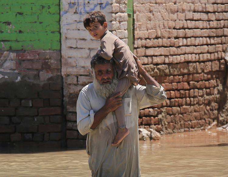En mand og et barn prøver at redde sig ud af de voldsomme oversvømmelser