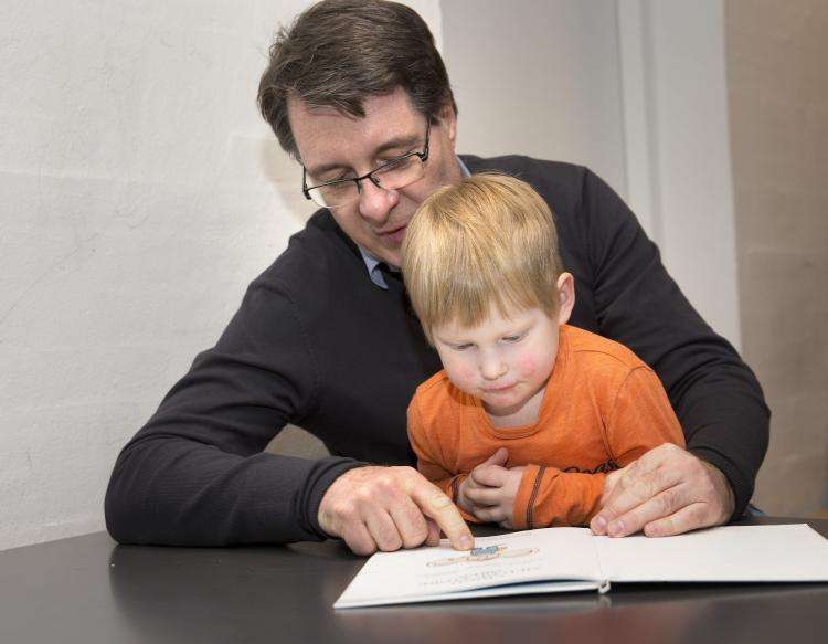 En mand læser højt for et barn